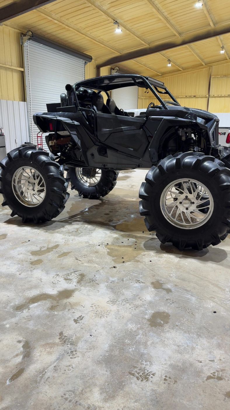 Polaris RZR cleaned up inside the detail shop, black bodywork and polished wheels